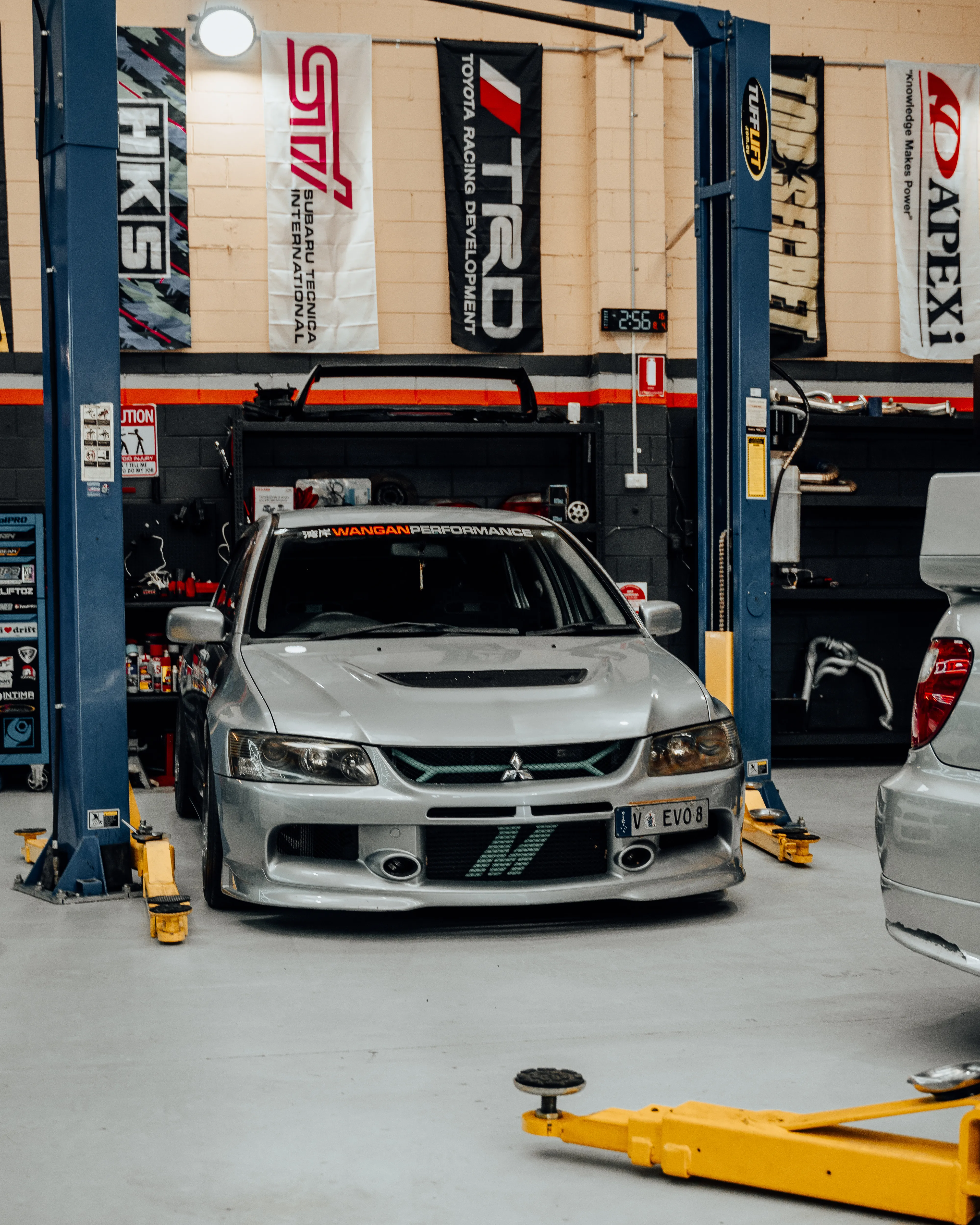 Mitsubishi Evo front-on under hoist at Wangan Performance workshop