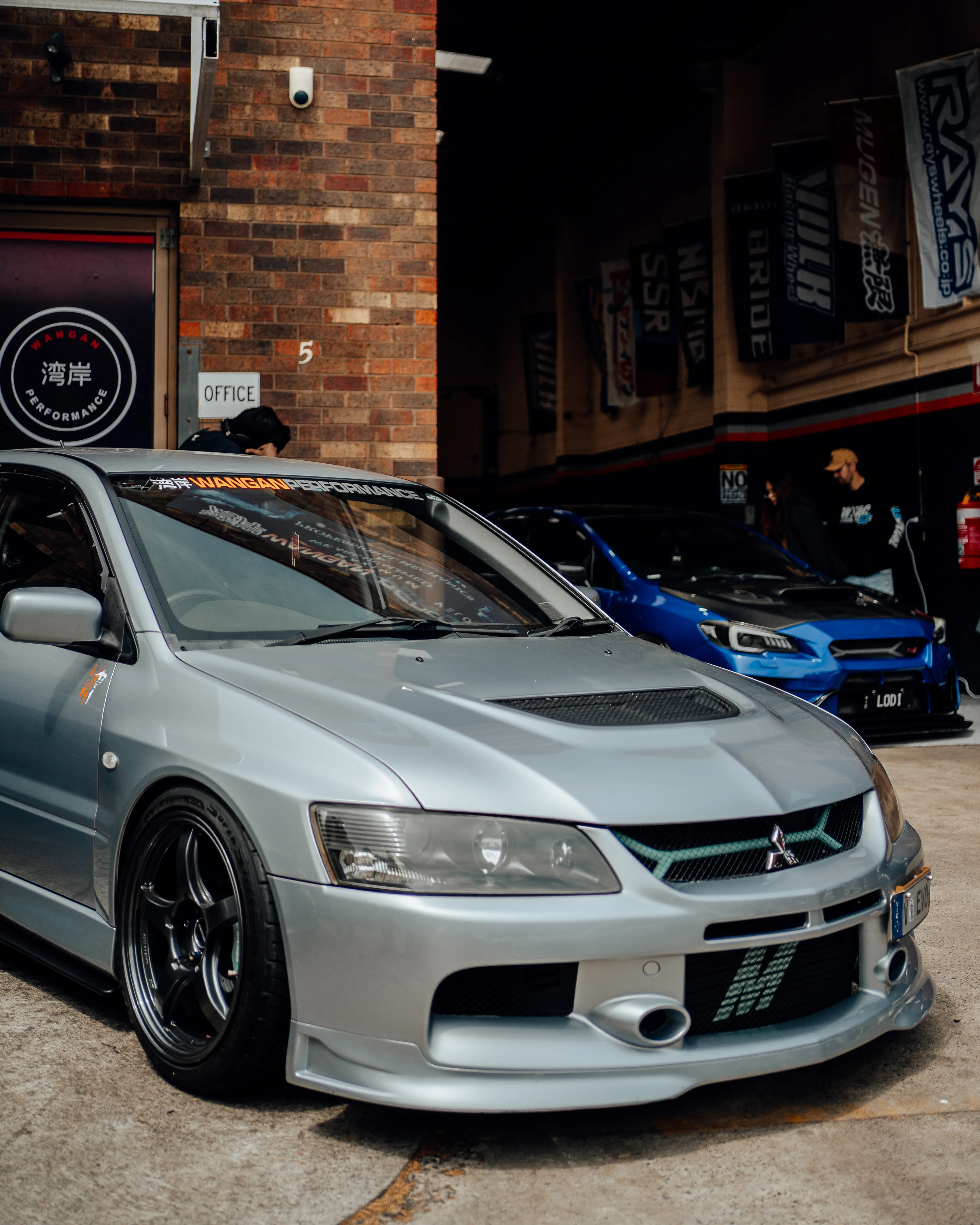 Mitsubishi Evo outside the Wangan Performance brick workshop with 湾岸 sign
